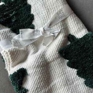 VIRAL pine tree throw blanket with pom pom border.